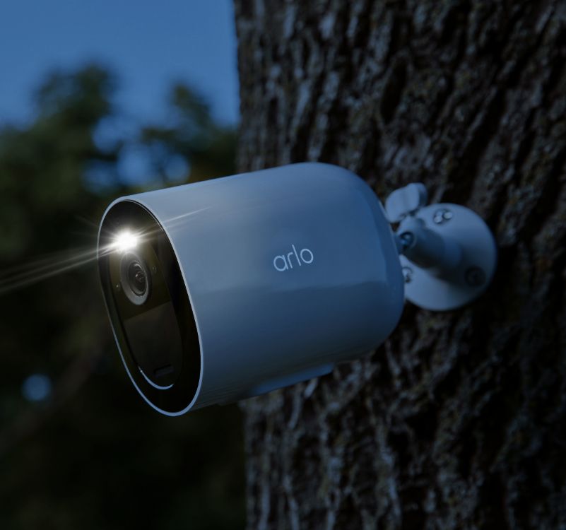 Una telecamera di sicurezza Arlo Go 2 che si appende a un albero sotto la pioggia ed è resistente all'acqua grazie al suo design resistente alle intemperie.