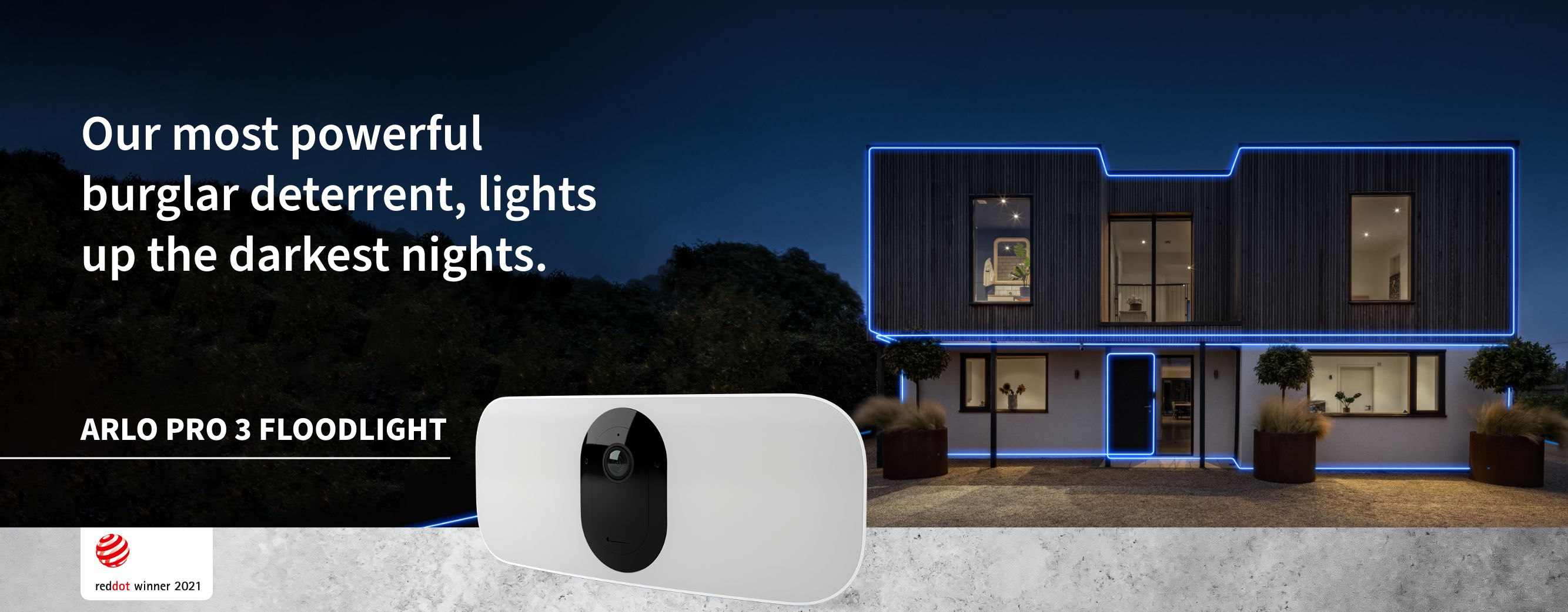 An Arlo Pro 3 Floodlight security camera attached to a wall outside shines a powerful shield of light  at night 