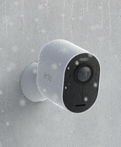 The Arlo security camera hangs against a wall in the rain and is weatherproof thanks to its water-resistant design.