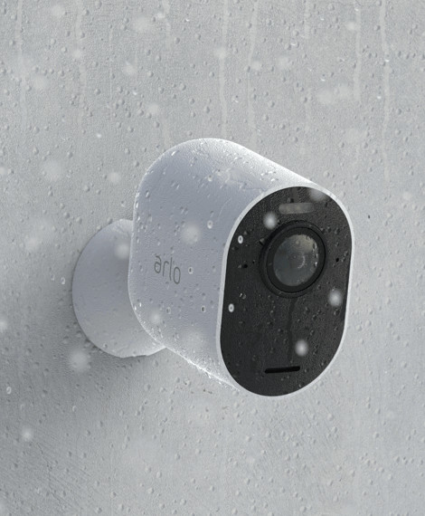 An Arlo security camera that hangs on a wall in the rain and is water resistant thanks to its weather resistant design