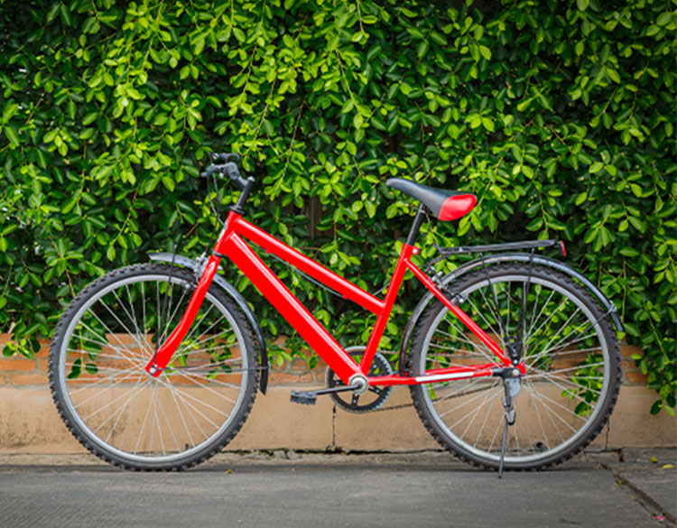 Ein rotes Fahrrad, das auf der Straße geparkt und durch die Arlo Go 2 Sicherheitskamera geschützt ist