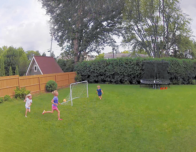 Barn som spiller fotball i en hage