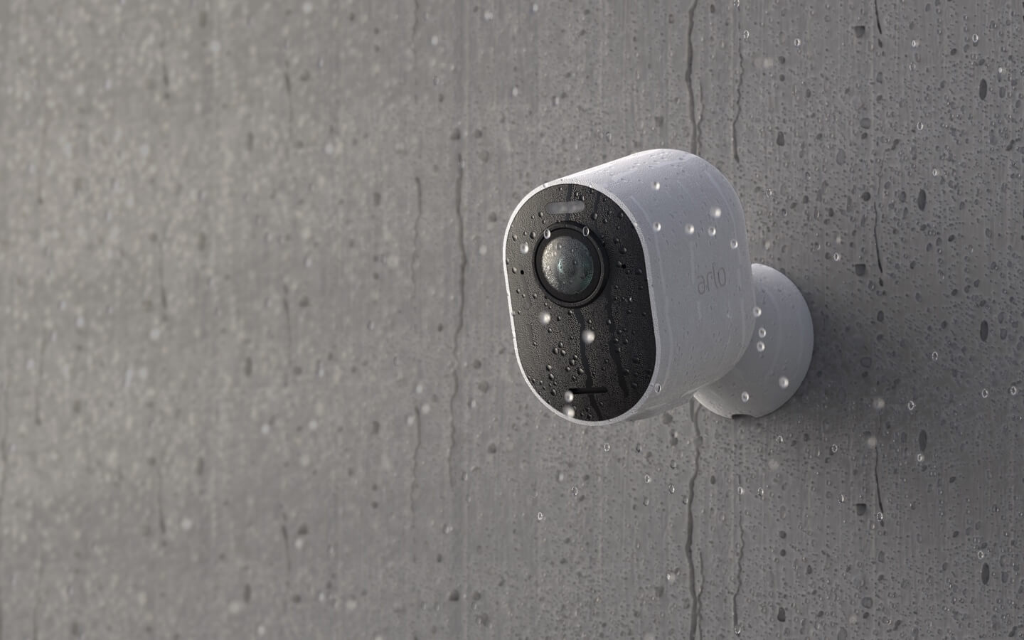 La caméra de surveillance Arlo Ultra 2 fixée à un mur sous la pluie qui résiste aux intempéries
