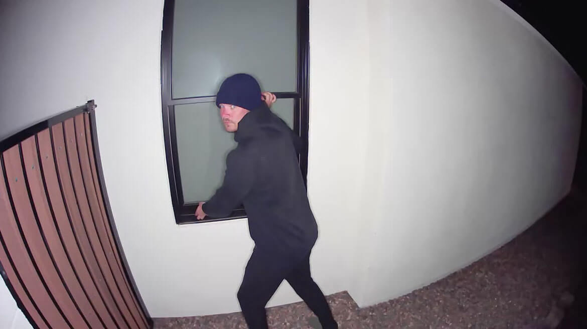 Włamywacz próbujący otworzyć okno w nocy uchwycony przez kamerę bezpieczeństwa Arlo