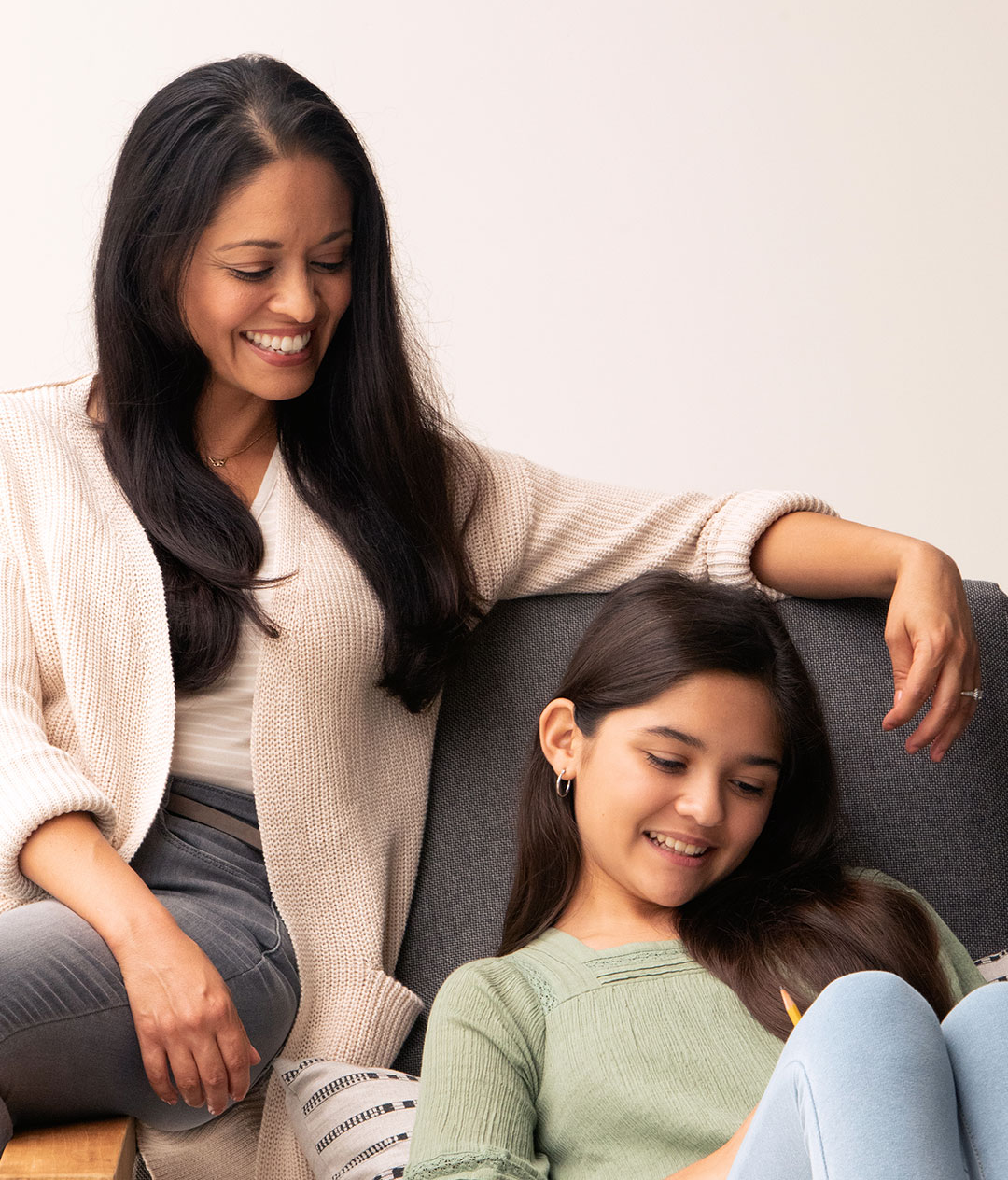 Image of mother and daughter at home sitting on couch