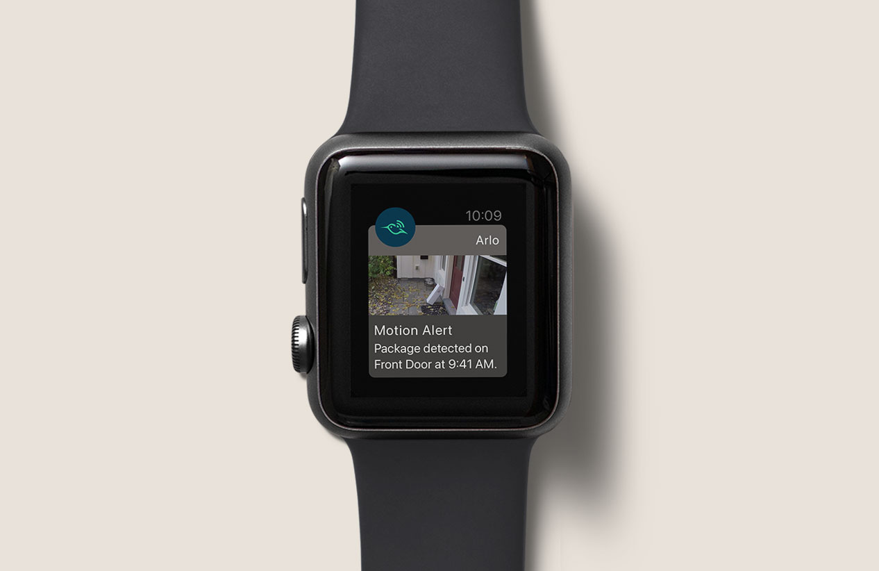 Person wearing Apple watch on wrist displaying Arlo motion alert